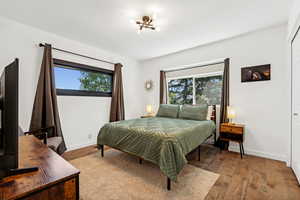 Bedroom featuring dark wood finished floors and baseboards