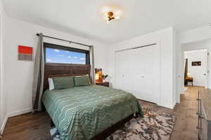 Bedroom with a closet and dark wood-style floors