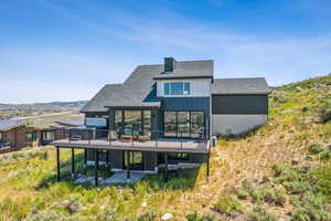 Back of property featuring a shingled roof, a patio, and a chimney