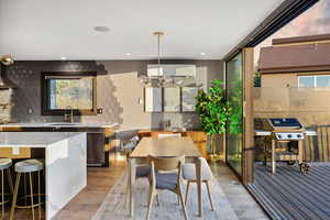 Dining room with light wood-type flooring, plenty of natural light, a chandelier, and recessed lighting