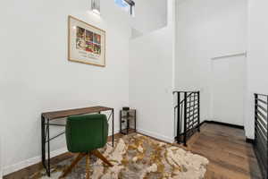 Office area featuring dark wood-type flooring and a high ceiling
