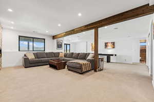 Living area with beam ceiling, light carpet, recessed lighting, and a fireplace
