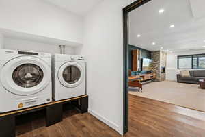 Laundry area featuring dark wood finished floors, recessed lighting, and separate washer and dryer
