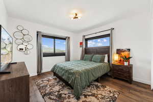 Bedroom with dark wood-style floors and baseboards