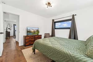 Bedroom with dark wood-type flooring and baseboards