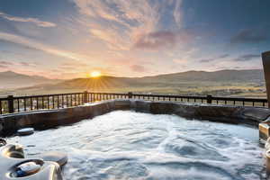 Wooden terrace featuring a mountain view and a hot tub