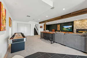 Rec room with carpet flooring, beamed ceiling, recessed lighting, and a fireplace