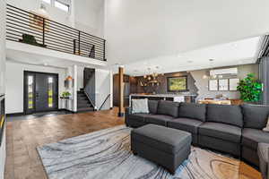 Living room featuring wood finished floors, plenty of natural light, stairs, recessed lighting, and a wall mounted air conditioner
