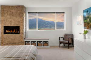 Bedroom with light colored carpet and a fireplace
