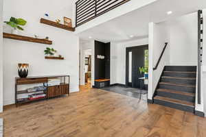 Entryway with recessed lighting, stairway, and wood finished floors