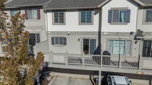Rear view of house featuring roof with shingles, board and batten siding, and a wooden deck