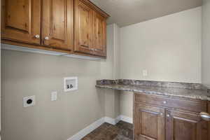 Washroom featuring cabinet space, washer hookup, a desk, electric dryer hookup, and a textured ceiling