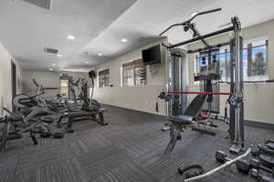 Gym featuring a textured ceiling and recessed lighting