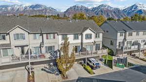 Rear view of house with a residential view, a shingled roof, a deck with mountain view, and stucco siding