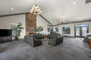 Living area with a chandelier, high vaulted ceiling, dark carpet, a fireplace, and recessed lighting