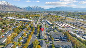 Aerial view of property and surrounding area featuring a mountainous background and a main thoroughfare