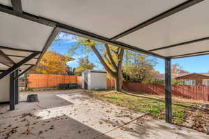 Fenced backyardhas a patio area and a shed