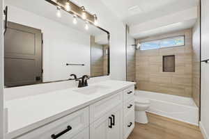 Full bathroom featuring vanity, light wood-style flooring, and washtub / shower combination