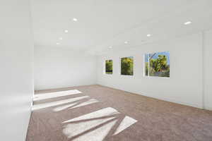 Carpeted empty room featuring recessed lighting and baseboards