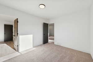 Spare room with baseboards and light carpet