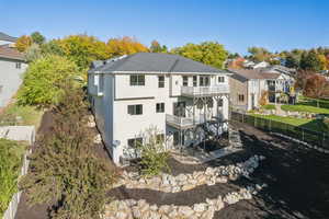 Rear view of house featuring a fenced backyard, a patio area, a balcony, a residential view, and stairs