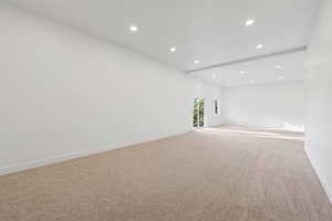 Spare room with recessed lighting, light colored carpet, and beamed ceiling