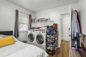 Bedroom featuring dark wood finished floors and washer and dryer