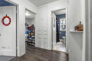 Corridor with dark wood-type flooring and baseboards