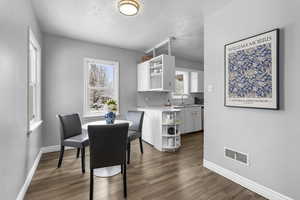 Dining area featuring dark wood-style floors and a textured ceiling