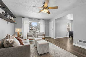 Living area featuring wood finished floors, ceiling fan, and a textured ceiling