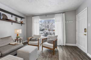 Living area with wood finished floors and a textured ceiling
