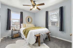Bedroom with carpet, a ceiling fan, cooling unit, and multiple windows