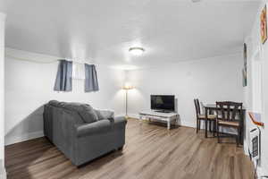 Living area with a textured ceiling and light wood-type flooring