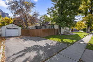 View of home's exterior featuring a garage, asphalt driveway, and an outdoor structure