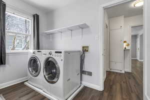 Laundry area with dark wood-style floors and washing machine and clothes dryer