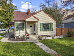 Bungalow with a garden, a chimney, and a shingled roof