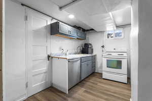 Kitchen with light countertops, appliances with stainless steel finishes, and dark wood-type flooring