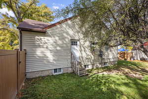 Back of property featuring entry steps and roof with shingles