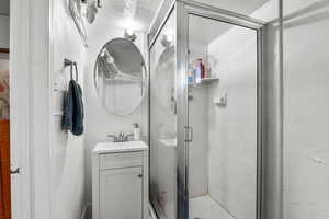 Bathroom featuring vanity, a stall shower, and a textured ceiling