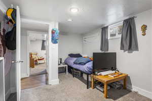 Bedroom with light carpet and a textured ceiling