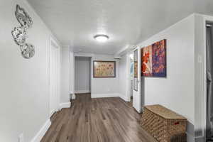 Hallway featuring a textured ceiling and wood finished floors