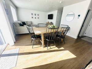 Dining area featuring wood finished floors and a textured ceiling
