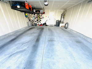 Garage featuring water heater and a garage door opener
