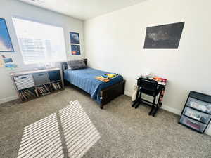 Bedroom featuring light carpet and a textured ceiling