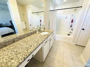 Ensuite bathroom with light tile patterned floors, shower / bath combination with curtain, vanity, and recessed lighting