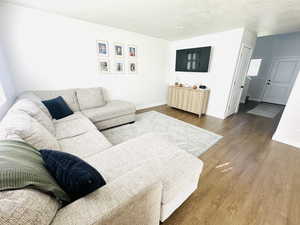 Living area featuring wood finished floors and a textured ceiling