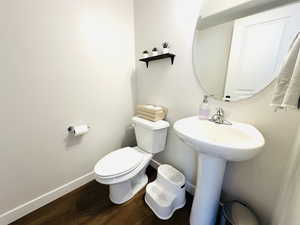Bathroom with baseboards and dark wood-type flooring