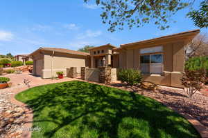 Rear view of house featuring stucco siding, an attached garage, a yard, and concrete driveway