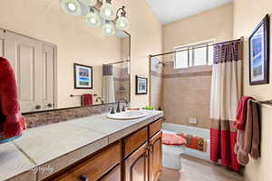 Full bathroom with vanity, shower / tub combo, and light wood-type flooring