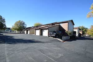 View of side of property with community garages and brick siding